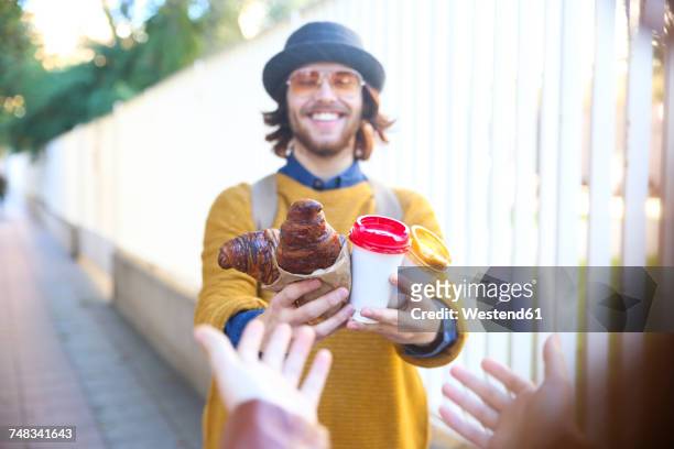 young man with croissant and coffee to go on the street - 2017 20 stock pictures, royalty-free photos & images