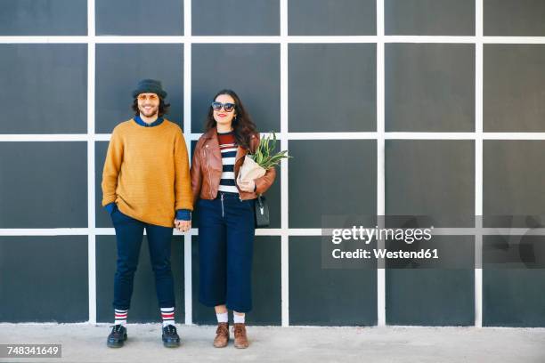 young couple hand in hand - side by side stock pictures, royalty-free photos & images