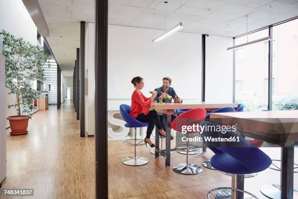 man and woman having lunch break in office - workplace canteen lunch stock pictures, royalty-free photos & images