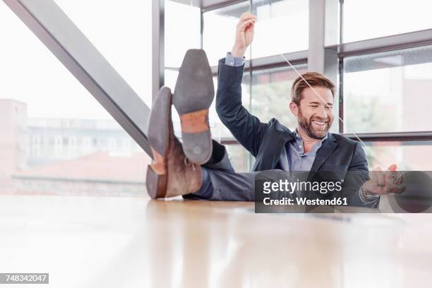 happy businessman putting his feet on the table playing with yoyo - yoyo photos et images de collection