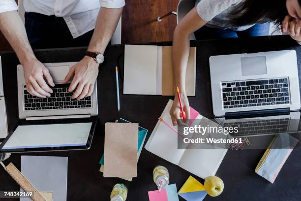 top view of man and woman using laptops and taking notes - student writing stock pictures, royalty-free photos & images