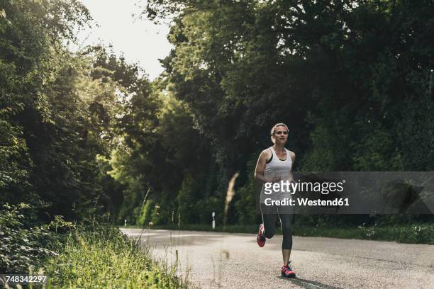 woman running on country road - 女性ランナー ストックフォトと画像