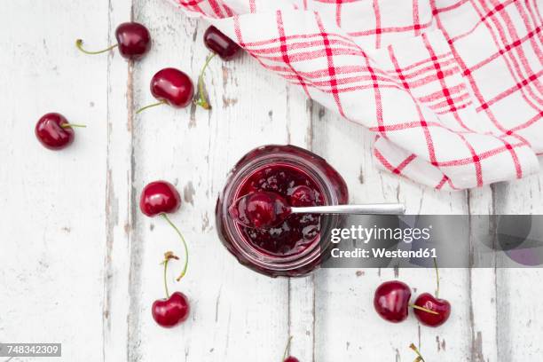 cherries beside open jar of cherry jam on white wood - pano da cozinha imagens e fotografias de stock