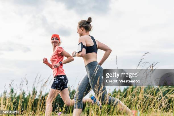 two women running in the countryside - jogging stock-fotos und bilder