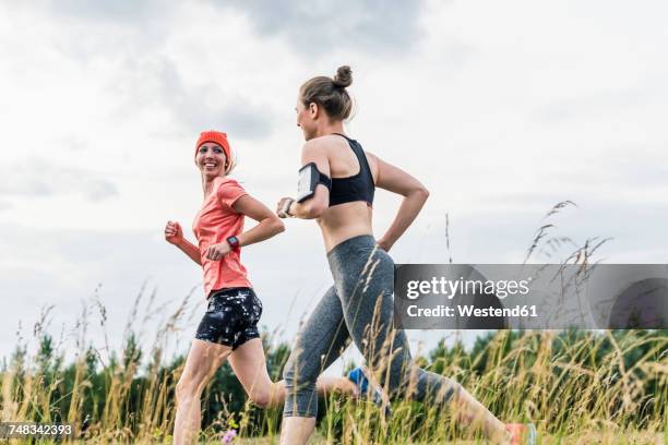 two women running in the countryside - run woman stockfoto's en -beelden