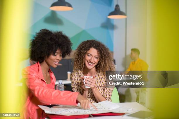 two women talking in office lounge - lounge room stock-fotos und bilder