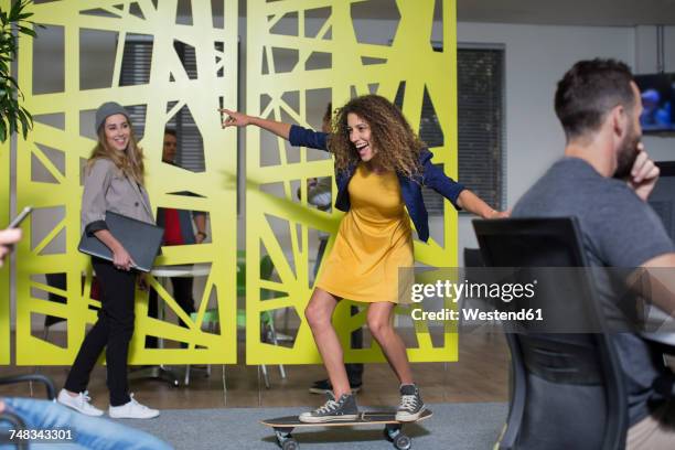 woman on skateboard in office having fun - funky office stock pictures, royalty-free photos & images