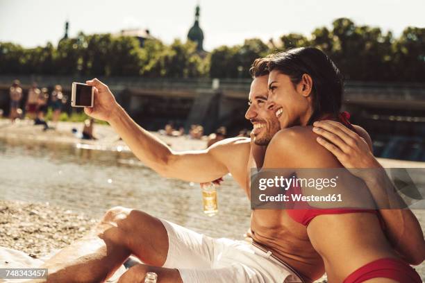 couple in love taking selfie on the beach - isar münchen stock pictures, royalty-free photos & images