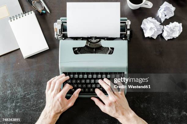 close-up of man using typewriter with crumpled paper on desk - macchina da scrivere foto e immagini stock