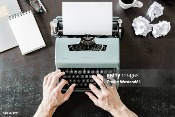 close-up of man using typewriter with crumpled paper on desk - タイプライター ストックフォトと画像