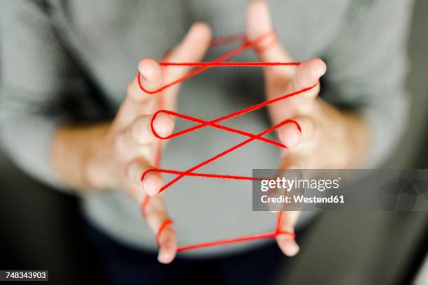 close-up of man holding string - rode draad stockfoto's en -beelden