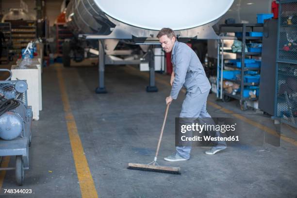 industrial worker sweeping floor - vegen stockfoto's en -beelden