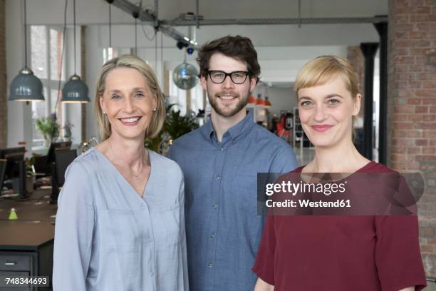 three smiling businesspeople in office - founder foto e immagini stock