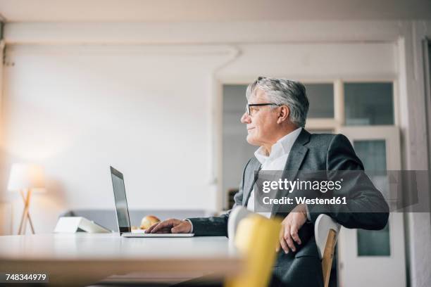 confident senior businessman using laptop - pleased laptop fotografías e imágenes de stock