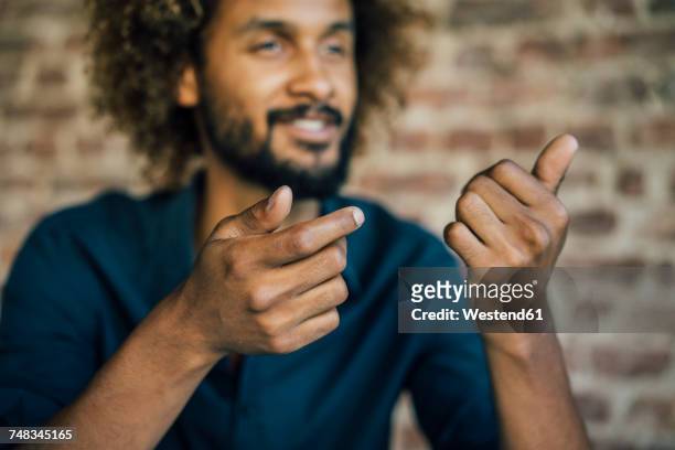 man with beard and curly hair gesticulating - hand gesture stock pictures, royalty-free photos & images
