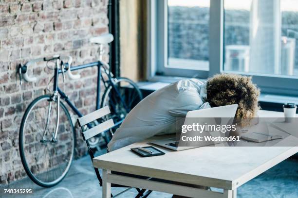 young man lying on desk - burn out stock-fotos und bilder