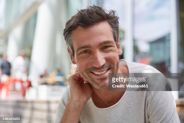 portrait of smiling man at an outdoor cafe - 40 year old stock pictures, royalty-free photos & images