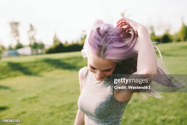 young woman with pink grey hair dancing on a meadow - woman silver hair young ストックフォトと画像