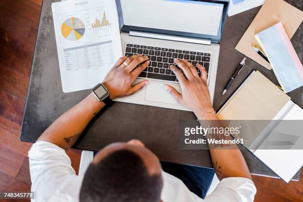 man using laptop at desk in home office - founder bildbanksfoton och bilder