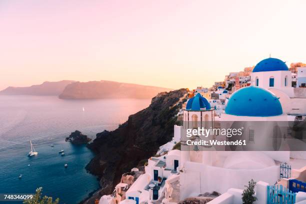 greece, santorini, oia, view to caldera and greek orthodox church at sunset - santorini stock pictures, royalty-free photos & images