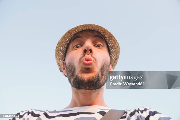 man with straw hat kissing to the camera - puckering - fotografias e filmes do acervo