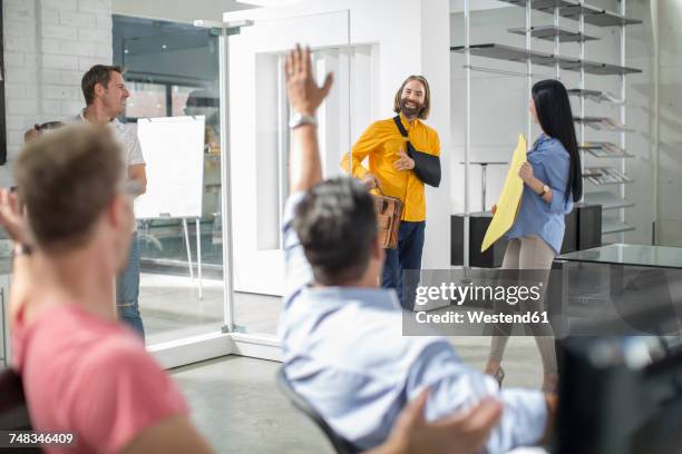 colleagues welcoming injured friend back - returning stock pictures, royalty-free photos & images