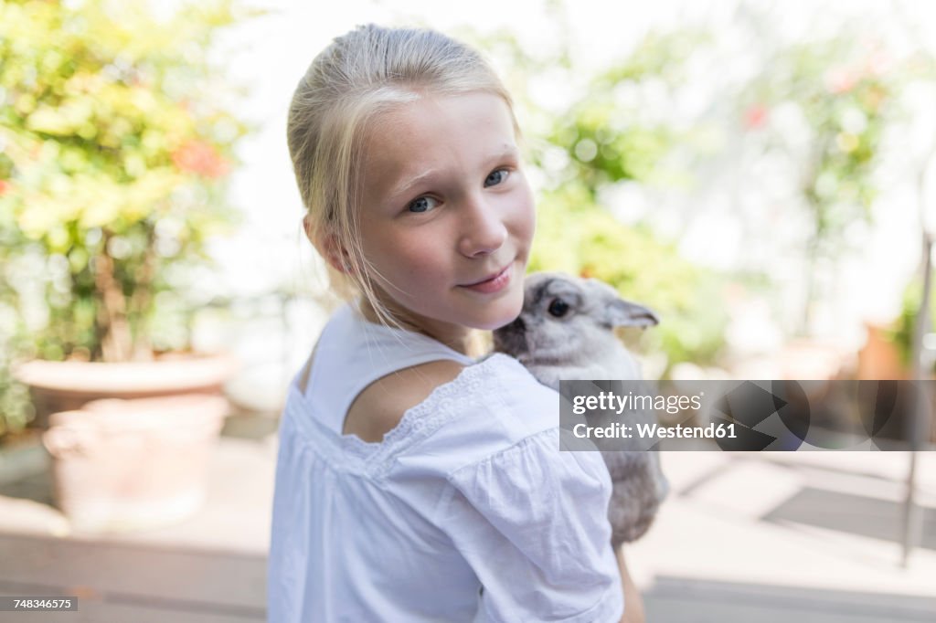 Portrait of girl with rabbit outdoors