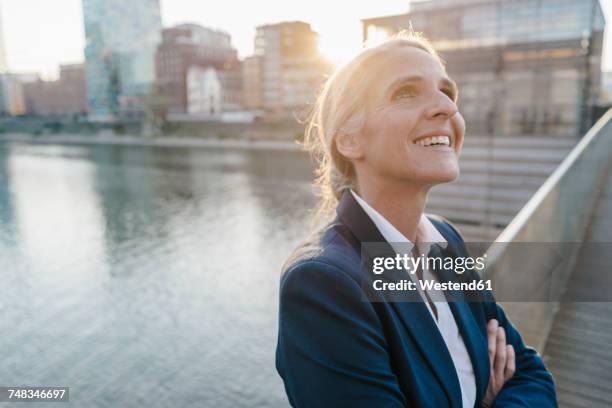 smiling businesswoman on bridge looking up - düsseldorf stock pictures, royalty-free photos & images