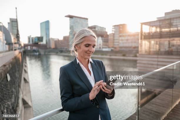 smiling businesswoman using cell phone on bridge - ethnicity stock pictures, royalty-free photos & images