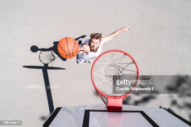 man playing basketball on outdoor court - basketball sport stock-fotos und bilder