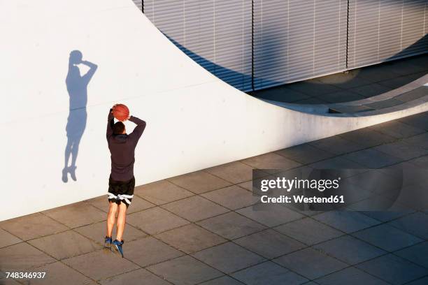 young man playing basketball in the city - drive ball sports fotografías e imágenes de stock