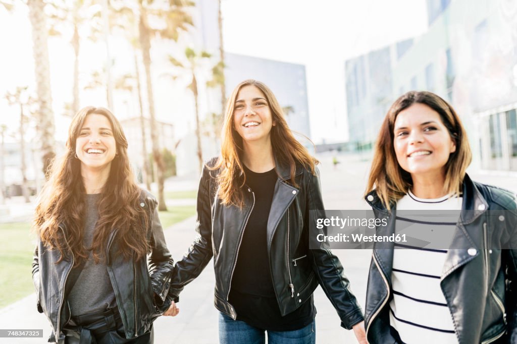 Three happy friends wearing black leather jackets