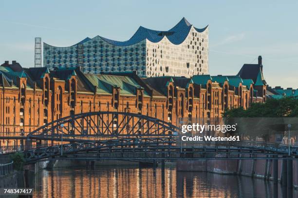 germany, hamburg, view to zollkanal and old warehouse district with elbe philharmonic hall in the background - speicherstadt stockfoto's en -beelden