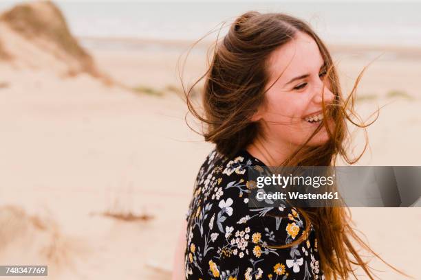 portrait of laughing woman with blowing hair on the beach - human hair strand stock pictures, royalty-free photos & images