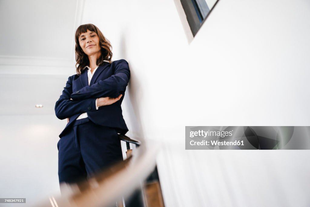 Successful businesswoman standing on staircase