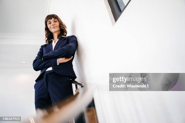 successful businesswoman standing on staircase - low angle view imagens e fotografias de stock