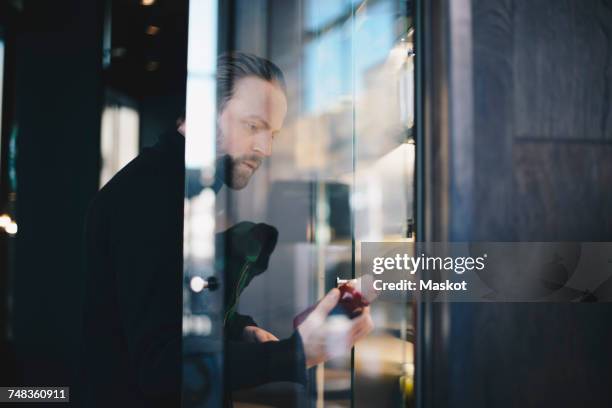 man analyzing bottle while looking at display cabinet in store - customer profile stock pictures, royalty-free photos & images