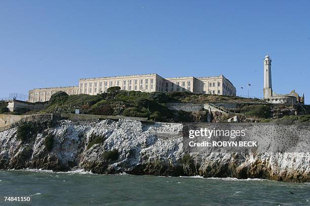 San Francisco, UNITED STATES: The main cell house is flanked by the lighthouse and the prision recreation yard and Alcatraz Island, 14 June 2007 in...