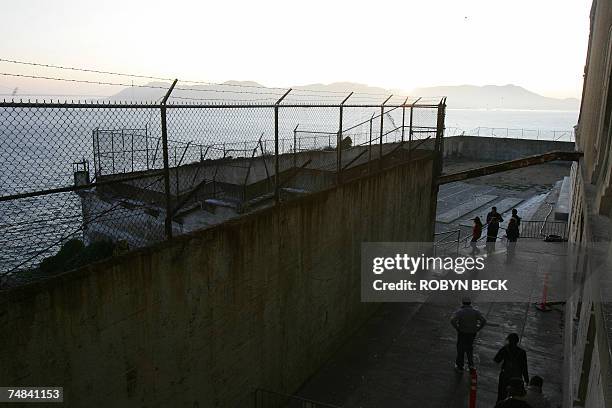 San Francisco, UNITED STATES: Tourists walk out of the main cell house into the recreation yard as they visit Alcatraz Island, 14 June 2007 in San...