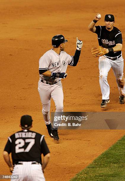 Derek Jeter of the New York Yankees gets caught in a rundown between second and third by shortstop Troy Tulowitzki and third baseman Garrett Atkins...