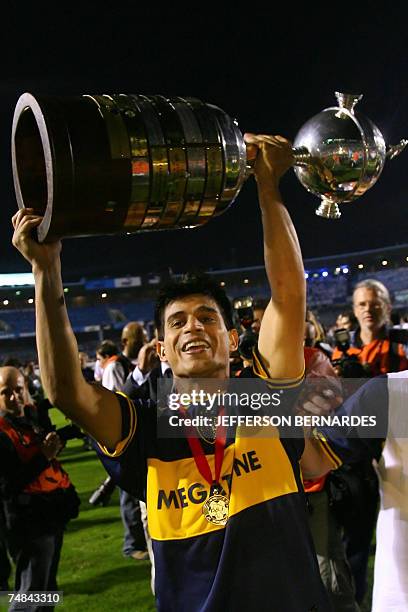 Boca Juniors' Hugo Benjamin Ibarra holds the Libertadores Cup trophy got after defeating Gremio by 2-0 in their final match, pose with the trophy 20...