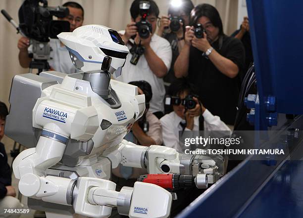 Photographers take photos of the HRP-3 Promet Mk-II humanoid robot during its press preview at Kawada Industry's laboratory in Haga town, near...