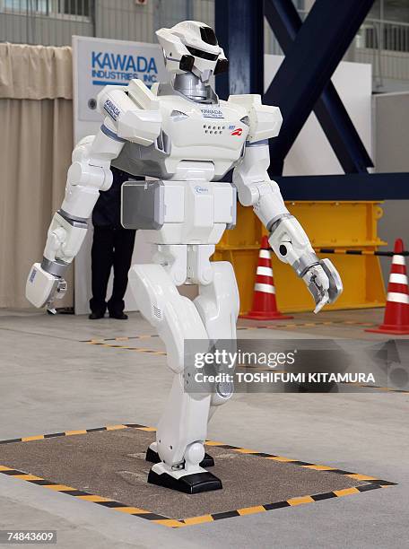 The HRP-3 Promet Mk-II humanoid robot walks on a sand covered surface during its press preview at Kawada Industry's laboratory in Haga town near...