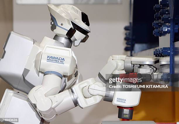 The HRP-3 Promet Mk-II humanoid robot balances its body while screwing a nut by an electronic impact wrench during its press preview at Kawada...