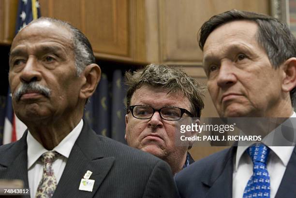 Washington, UNITED STATES: US movie maker Michael Moore listens to politicians as he stands behind US Rep.and US Presidential Candidate Dennis J....