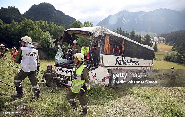 Members of the Austrian firebrigade steer a crashed German Tourist bus out of a pasture on June 21, 2007 near Reutte, Austria. One person was killed...