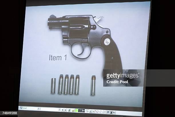 Photograph showing the gun that killed Lana Clarkson with the rounds of ammunition recovered from the cylinder of the gun is displayed on a screen in...