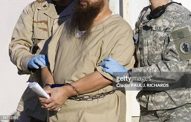 In this 06 December 2006 file photo, a detainee is escorted by military guards from his annual Admistrative Review Board hearing at the US Naval base...