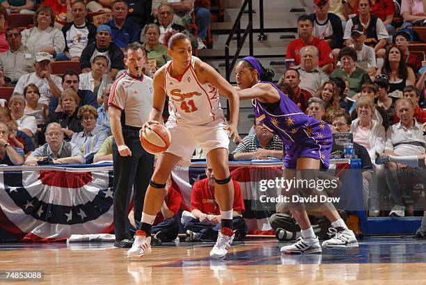 Erika Desouza of the Connecticut Sun moves the ball against Jessica Moore of the Los Angeles Sparks during a WNBA game at the Mohegan Sun Arena on...