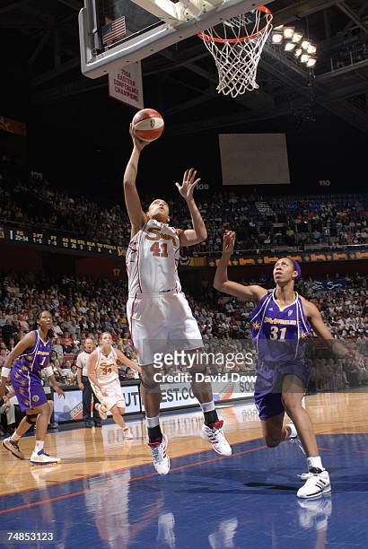 Erika Desouza of the Connecticut Sun goes up for a shot against Jessica Moore of the Los Angeles Sparks during a WNBA game at the Mohegan Sun Arena...